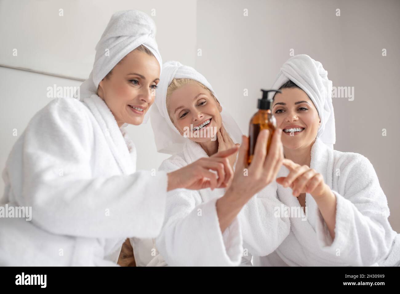 Mujeres con entusiasmo considerando el producto cosmético Foto de stock