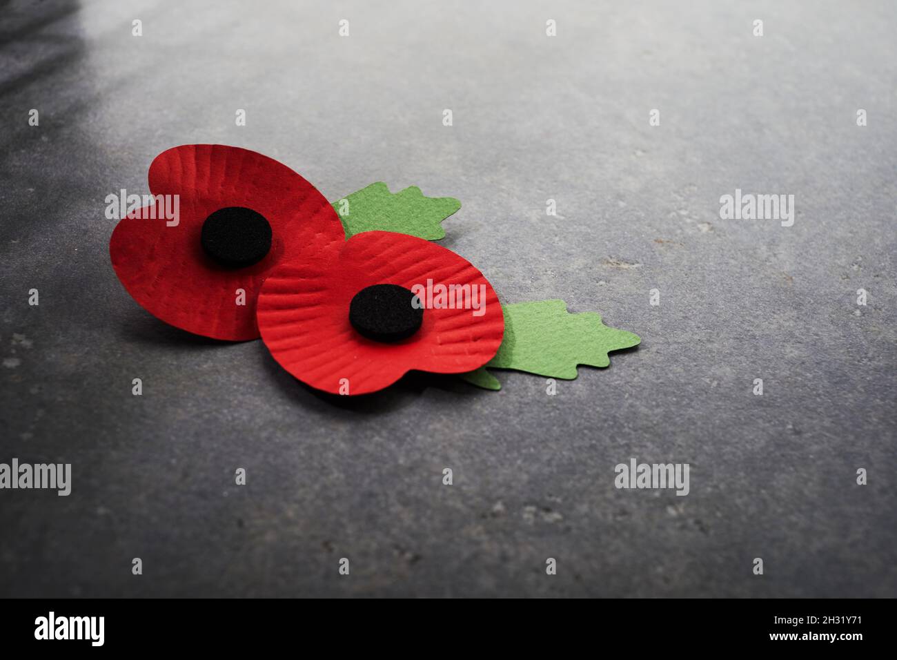 Día del recuerdo de la Guerra Mundial. La amapola roja es un símbolo de  recuerdo para los caídos en la guerra. Amapolas rojas sobre fondo de piedra  oscura Fotografía de stock 
