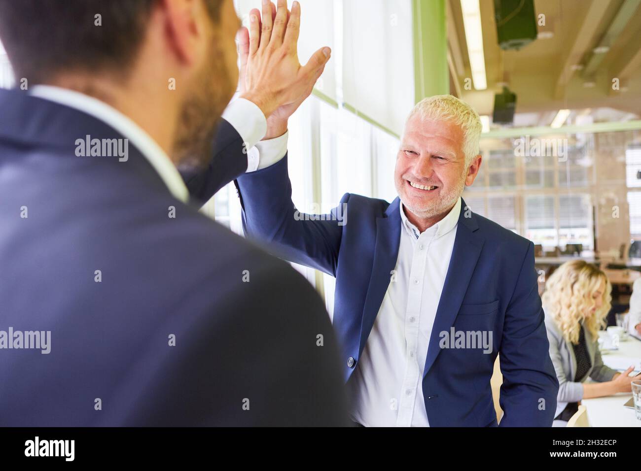 Hombre de negocios senior como gerente que da un alto cinco a un socio de negocios Foto de stock