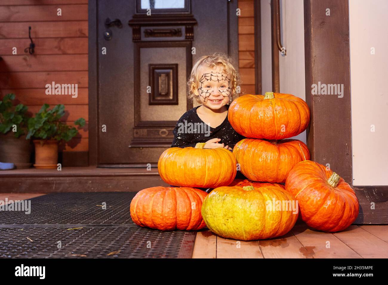 Un niño celebra Halloween. El porche y la puerta principal de la casa están  decoradas con calabazas. Decoración de Halloween Fotografía de stock - Alamy