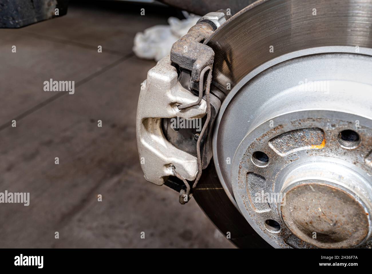 Nuevas pinzas de freno traseras y discos de freno con pastillas en un  vehículo de pasajeros, en un gato de coche en el taller Fotografía de stock  - Alamy