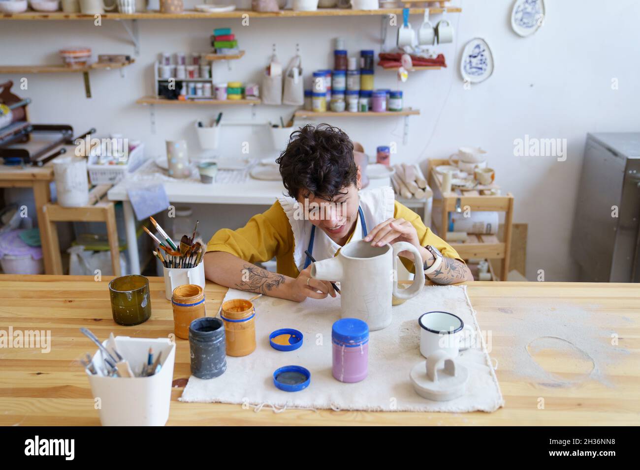 Joven niña feliz artista se concentró en la pintura y decoración de cerámica  en el taller de clases de arte Fotografía de stock - Alamy