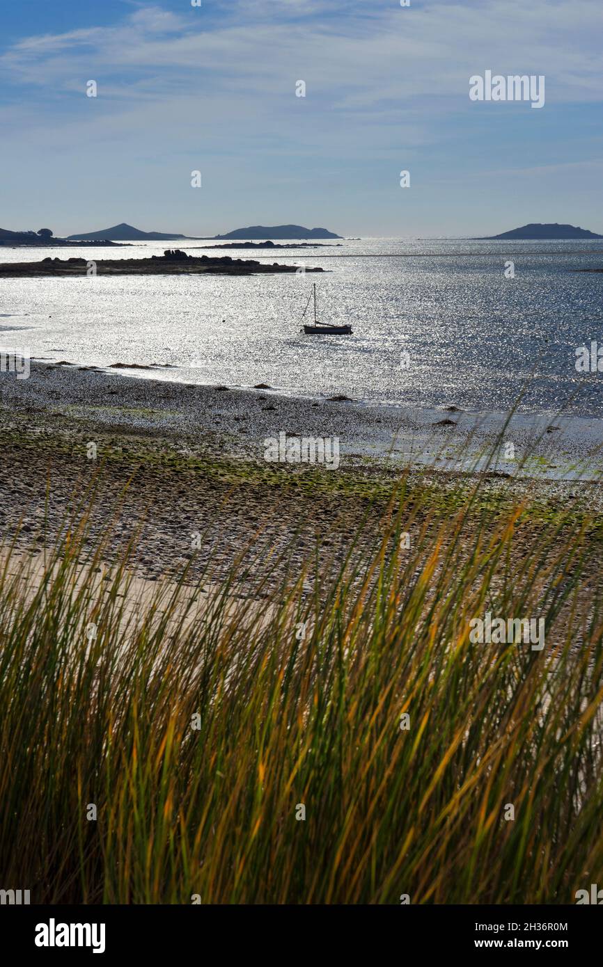 Dunas de arena, playa y barco mirando hacia las islas del este en St Martins, Islas de Scilly, Inglaterra Foto de stock