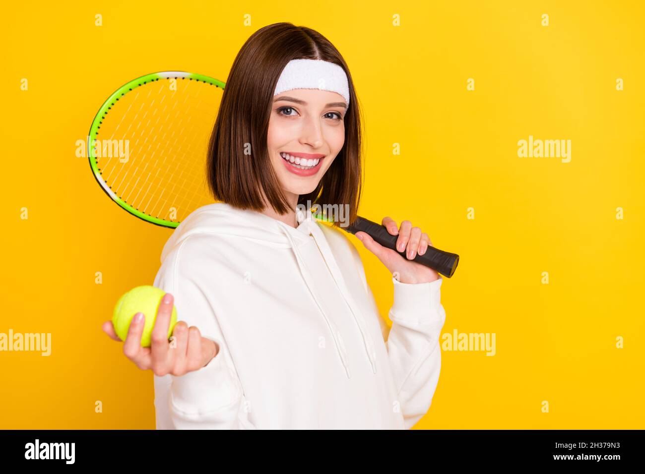 Foto del jugador de tenis deportivo dama sostener racket ball usar banda de  sujeción blanca sudadera aislado de color amarillo fondo Fotografía de  stock - Alamy