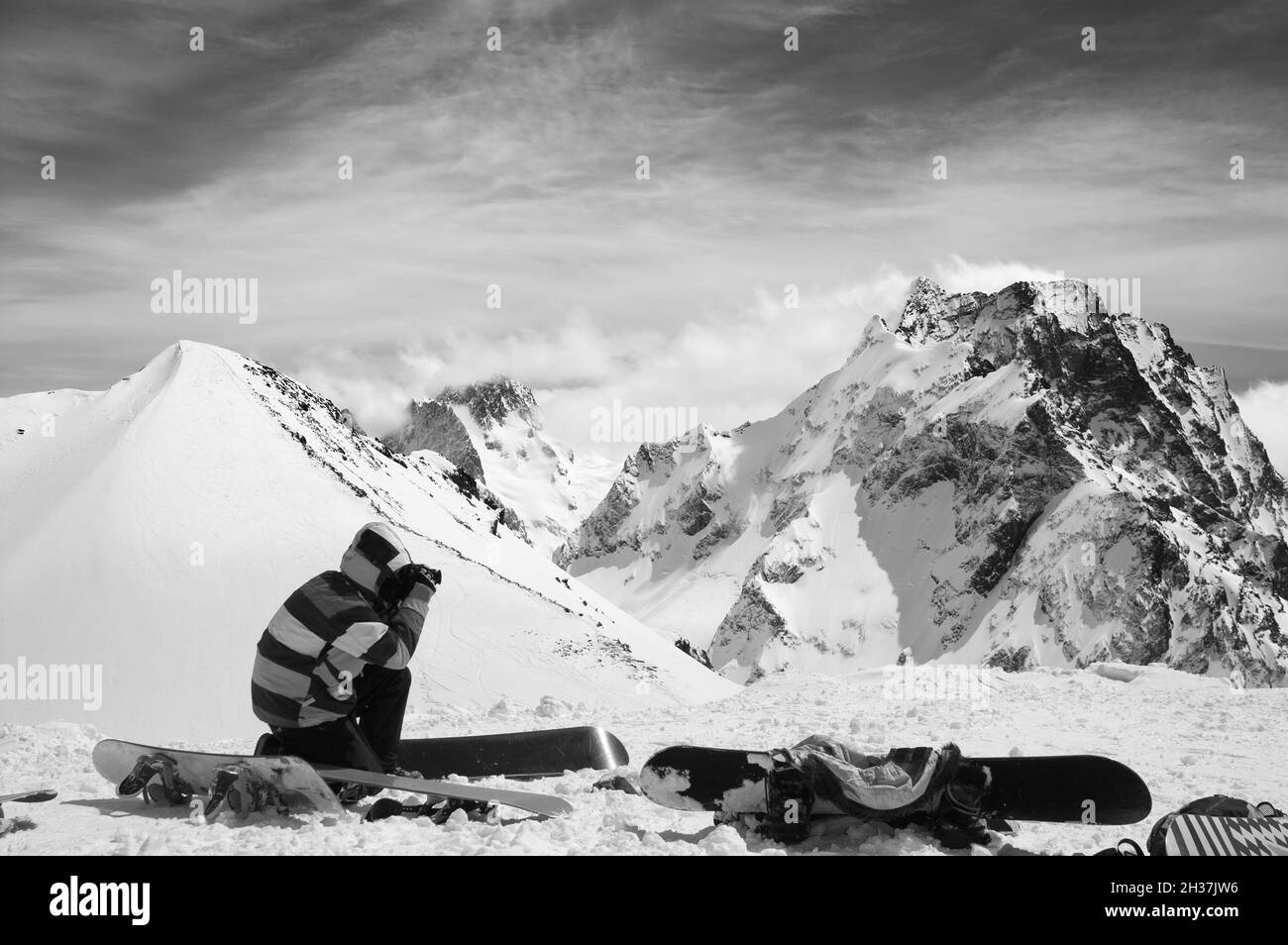 Tablas de snowboard con nieve pendiente y snowboarder hacer fotos con la cámara en alta montaña invernal. Montañas del Cáucaso, región Dombay-Ulgen Dombay, montajes y mu Foto de stock