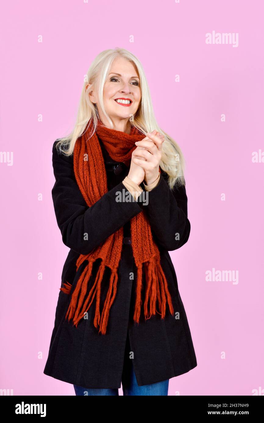 Atractiva Señora Blonde tomada sobre fondo rosa palmas manos Foto de stock