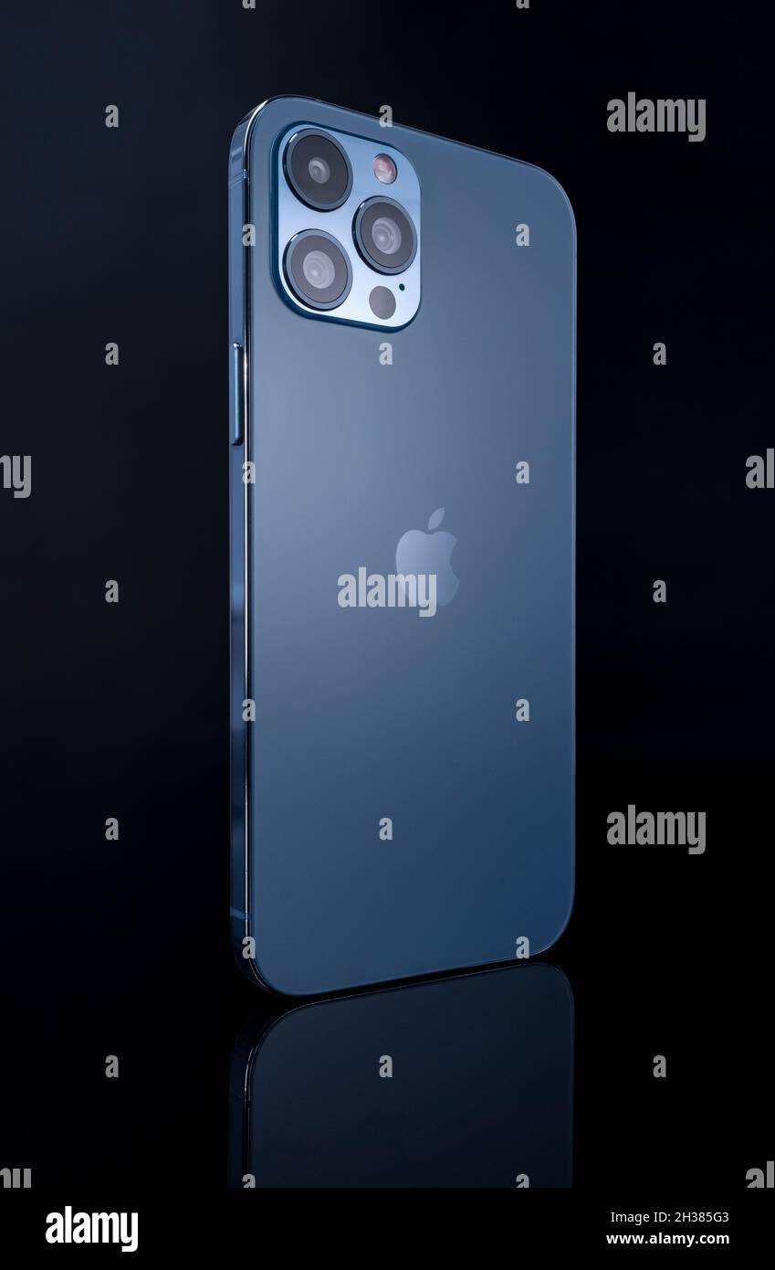 Galati, Rumania - 14 de octubre de 2021: Estudio de lanzamiento del nuevo Apple iPhone 12 Pro Max color azul, vista posterior con el logotipo de Apple. Aísle el fondo de vidrio negro Foto de stock