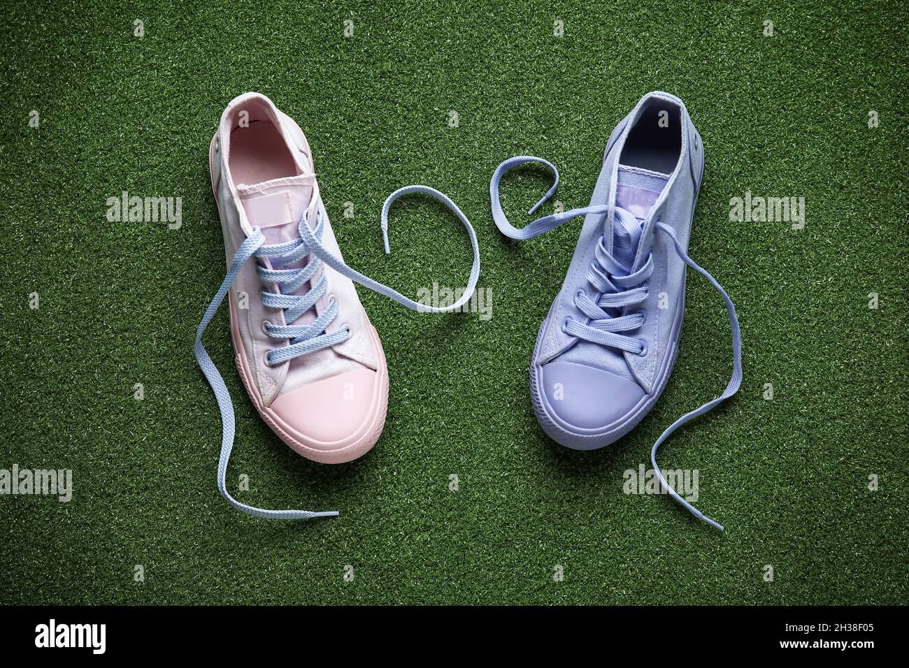 Diferentes zapatillas con cordones desatados sobre fondo de color  Fotografía de stock - Alamy