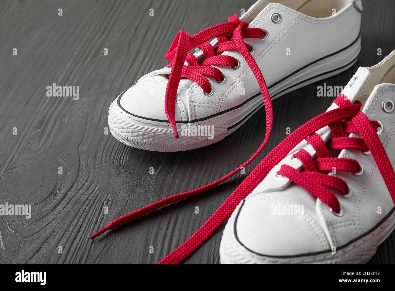 Zapatos con cordones rojos sobre fondo de madera oscura, primer plano  Fotografía de stock - Alamy