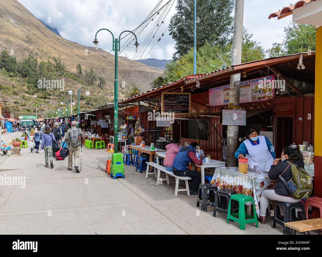La comida está a lo largo de la calle concurrida hasta la estación de tren. Ollantaytambo, Cuzco, Perú. Foto de stock