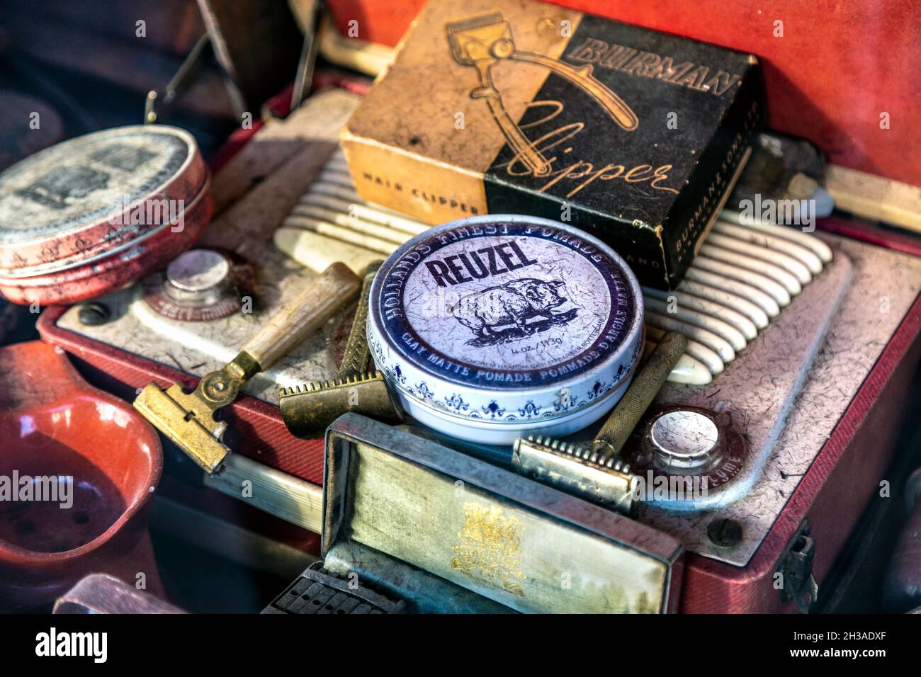 Exposición de accesorios de la tienda de babrers vintage y retro, maquinillas de afeitar, productos para el cabello (Palace Barber, East Molesey, Londres, Reino Unido) Foto de stock