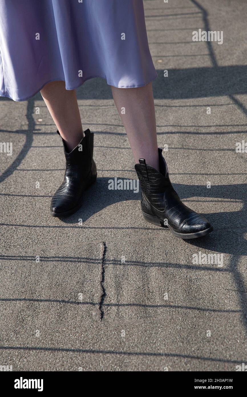 Patas de mujer blanca en falda negras en el Fotografía de stock -