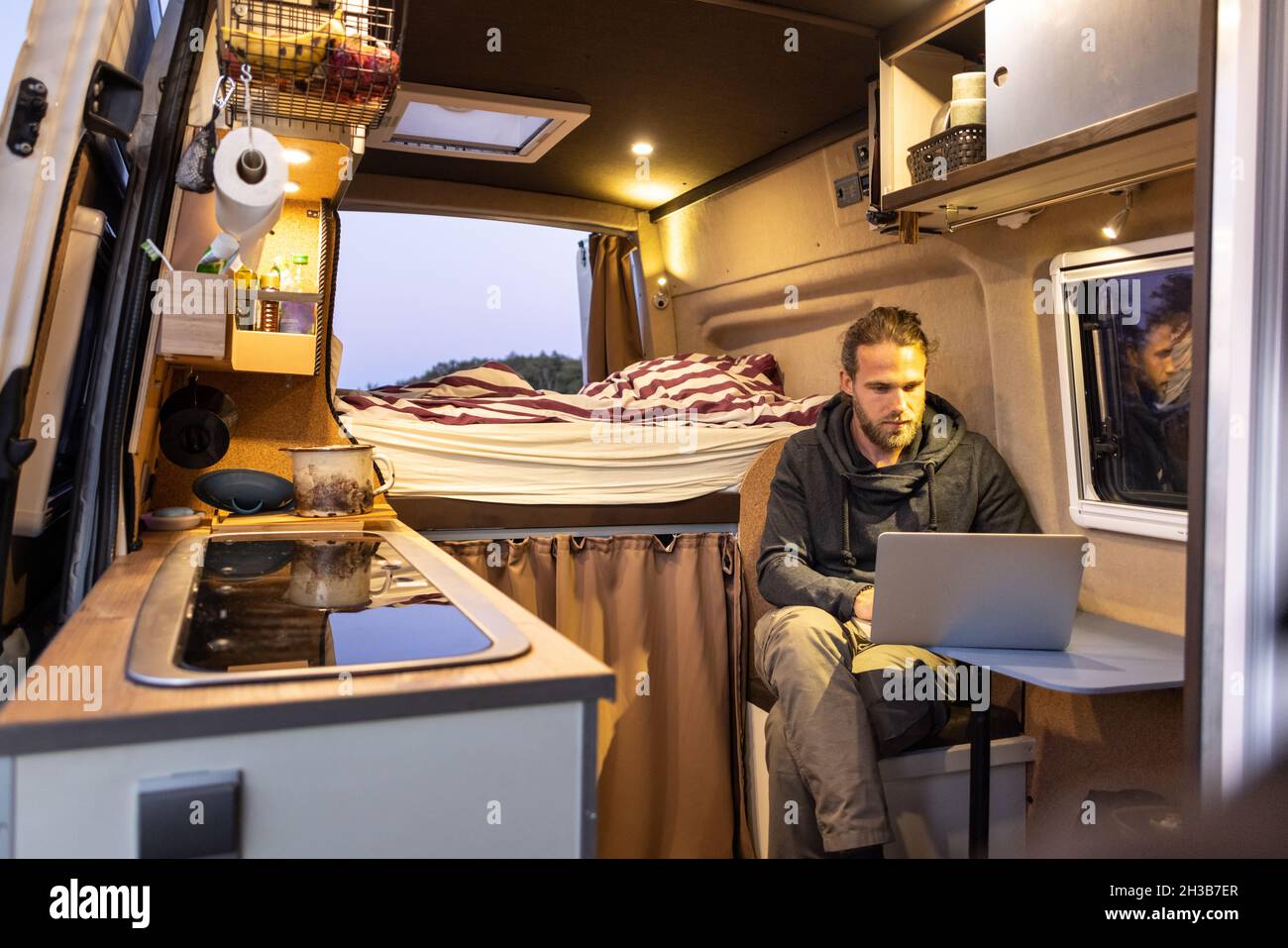 Hombre usando un ordenador portátil dentro de su camioneta Foto de stock