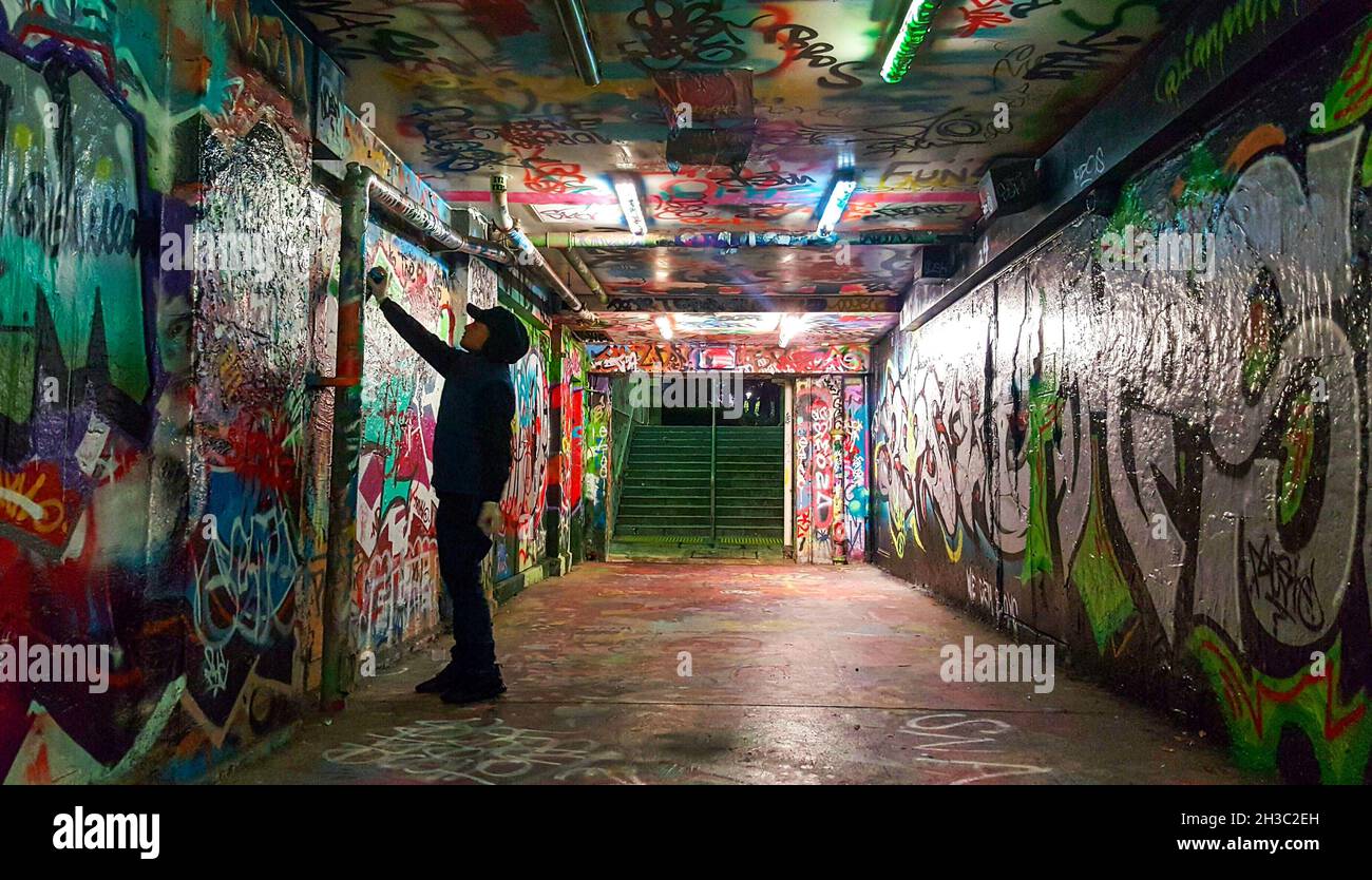 SYDN, AUSTRALIA - 17 de septiembre de 2021: Un artista de Graffiti Spraypintas Wall en Sydney Uni's Public Grafitti Tunnel, Sydney, Australia Foto de stock