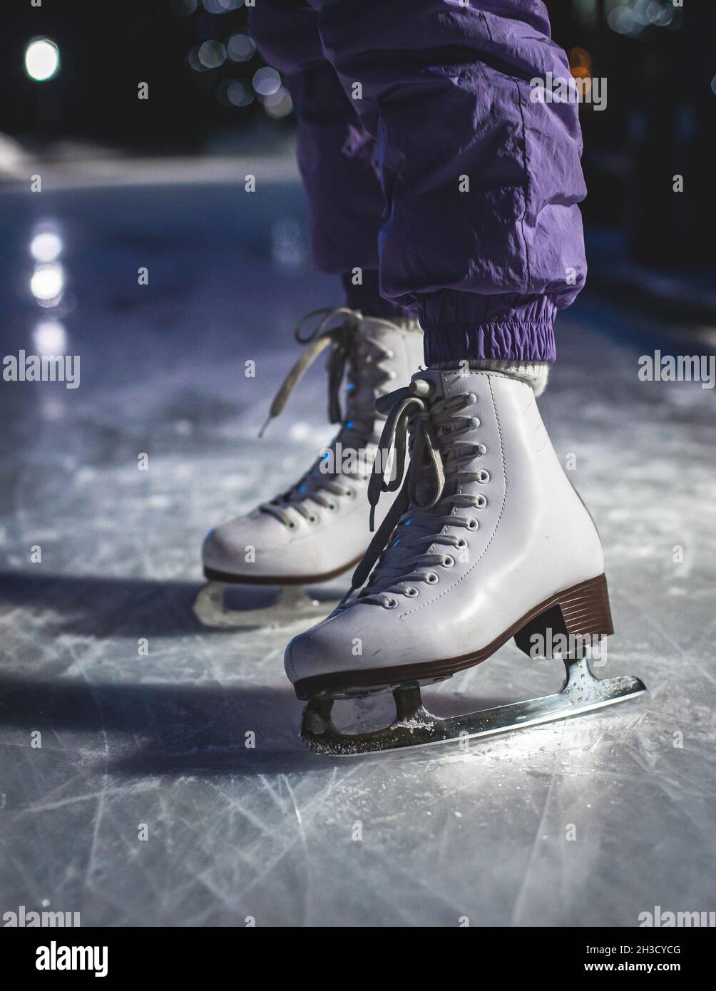 Vista de cerca de nuevos patines de hielo blanco botas en pista en  movimiento, niña patinaje sobre hielo en la arena, el concepto de patinaje  sobre hielo en invierno, Navidad de vacaciones