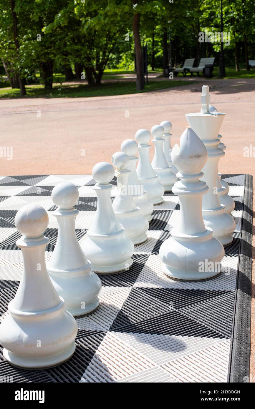 Piezas de ajedrez gigantes para jugar al aire libre, fotografía vertical.  Piezas de ajedrez blancas en un tablero de ajedrez Fotografía de stock -  Alamy
