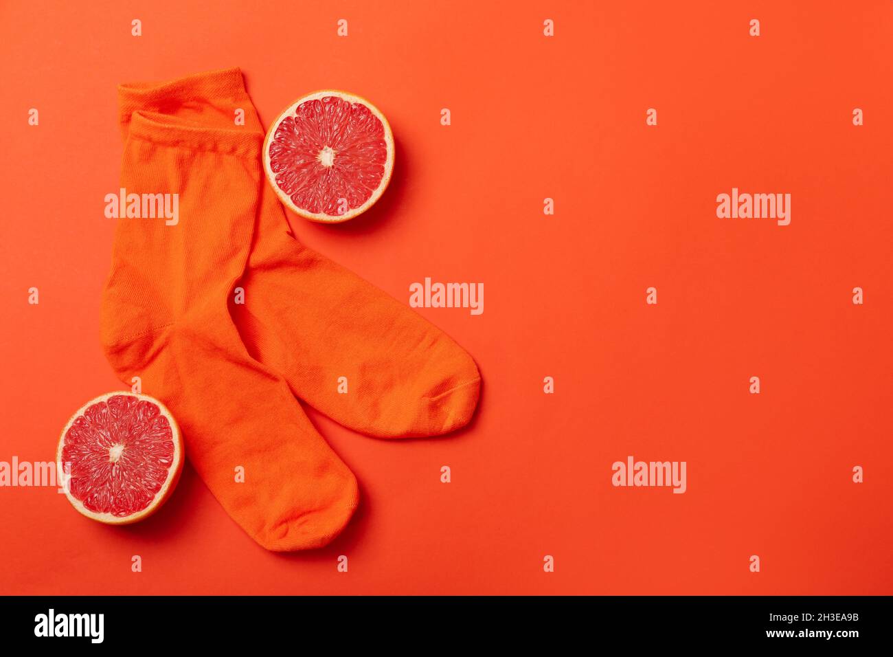 Calcetines de naranja y pomelo sobre fondo naranja Foto de stock