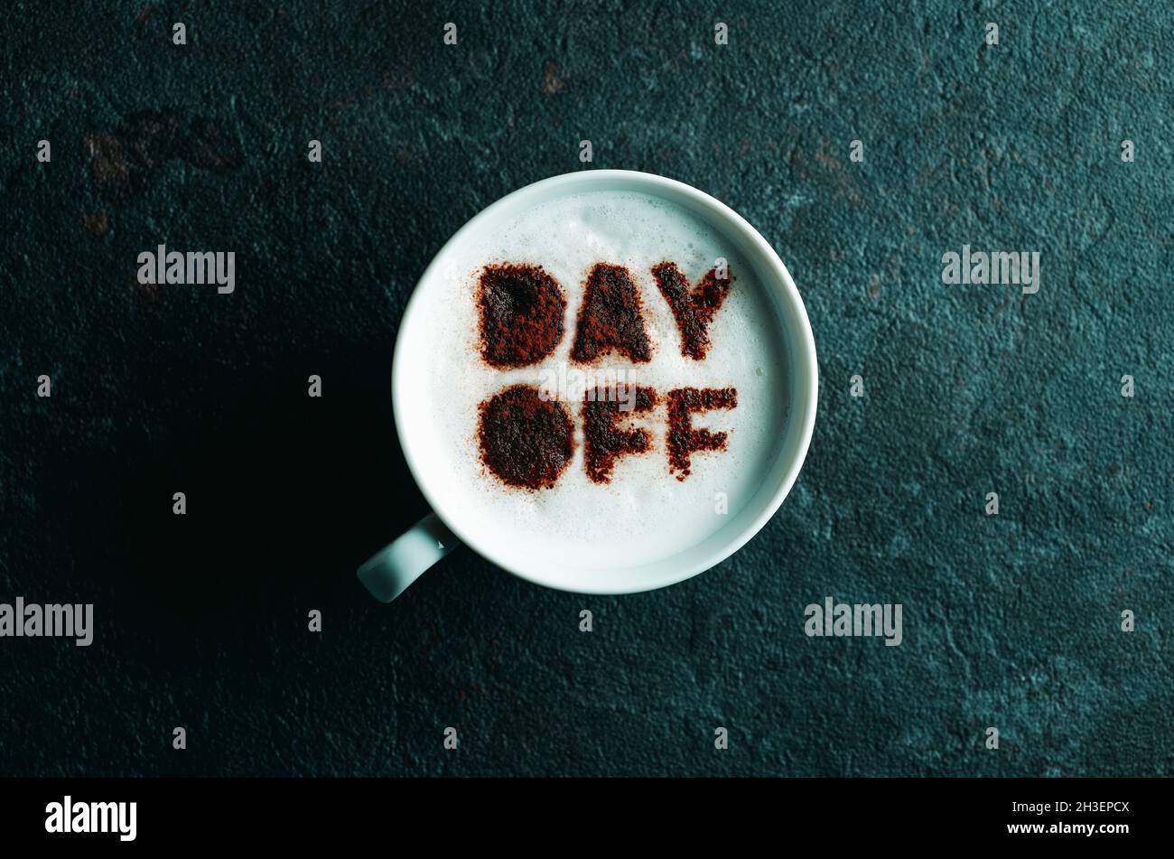 vista en ángulo de una taza de cappuccino con el texto del día libre escrito con cacao en polvo en su espuma de leche Foto de stock