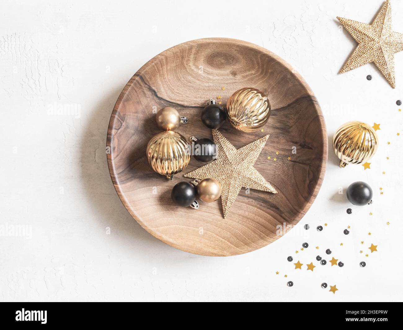 Fondo de Navidad o Año Nuevo - plato de madera con varias bolas de Navidad y estrella de oro sobre fondo blanco. Decoración para el hogar, decoración de vacaciones. Foto de stock