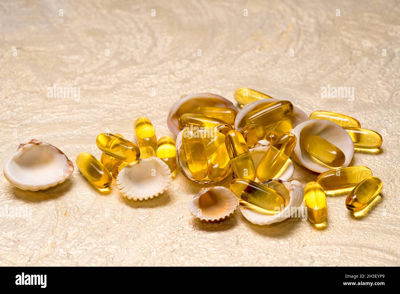 El montón de cápsulas de aceite de grasa de pescado Omega-3 se encuentra en las pequeñas conchas como un tesoro. Espacio de copia para el texto. EPA y DHA son sustancias grasas esenciales que tú Foto de stock