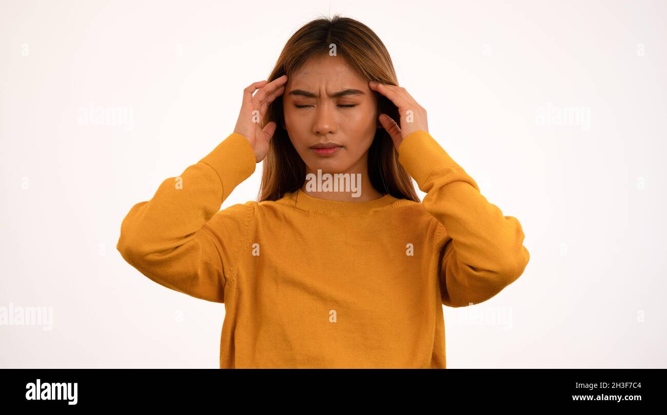Joven atractiva mujer asiática con dolor de cabeza en el estudio Foto de stock
