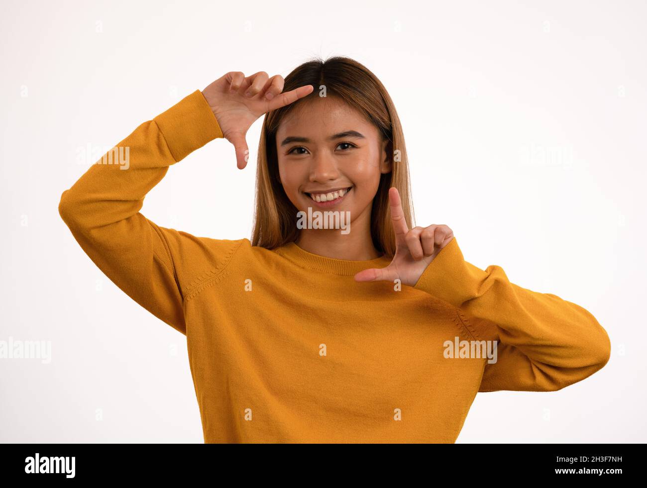 Joven atractiva chica asiática feliz posando en el estudio Foto de stock