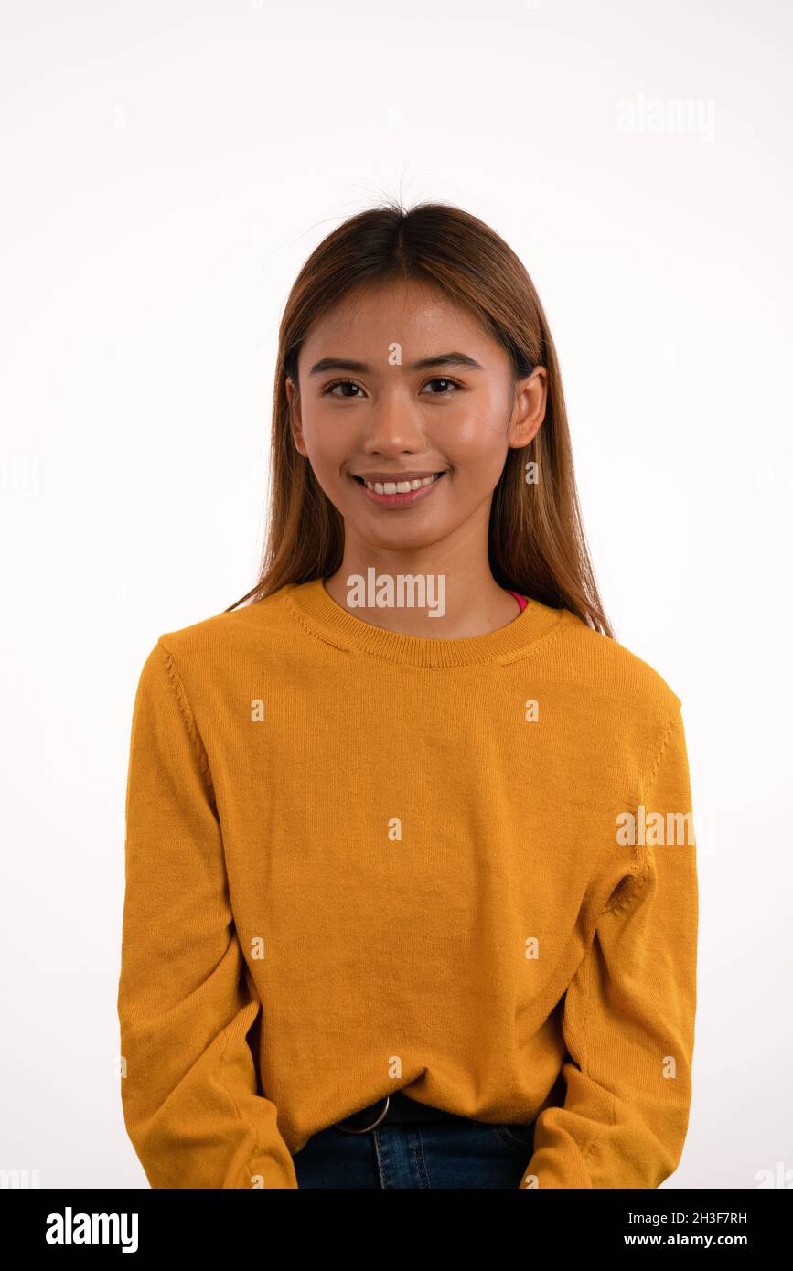 Joven atractiva chica asiática sonriendo en el estudio Foto de stock