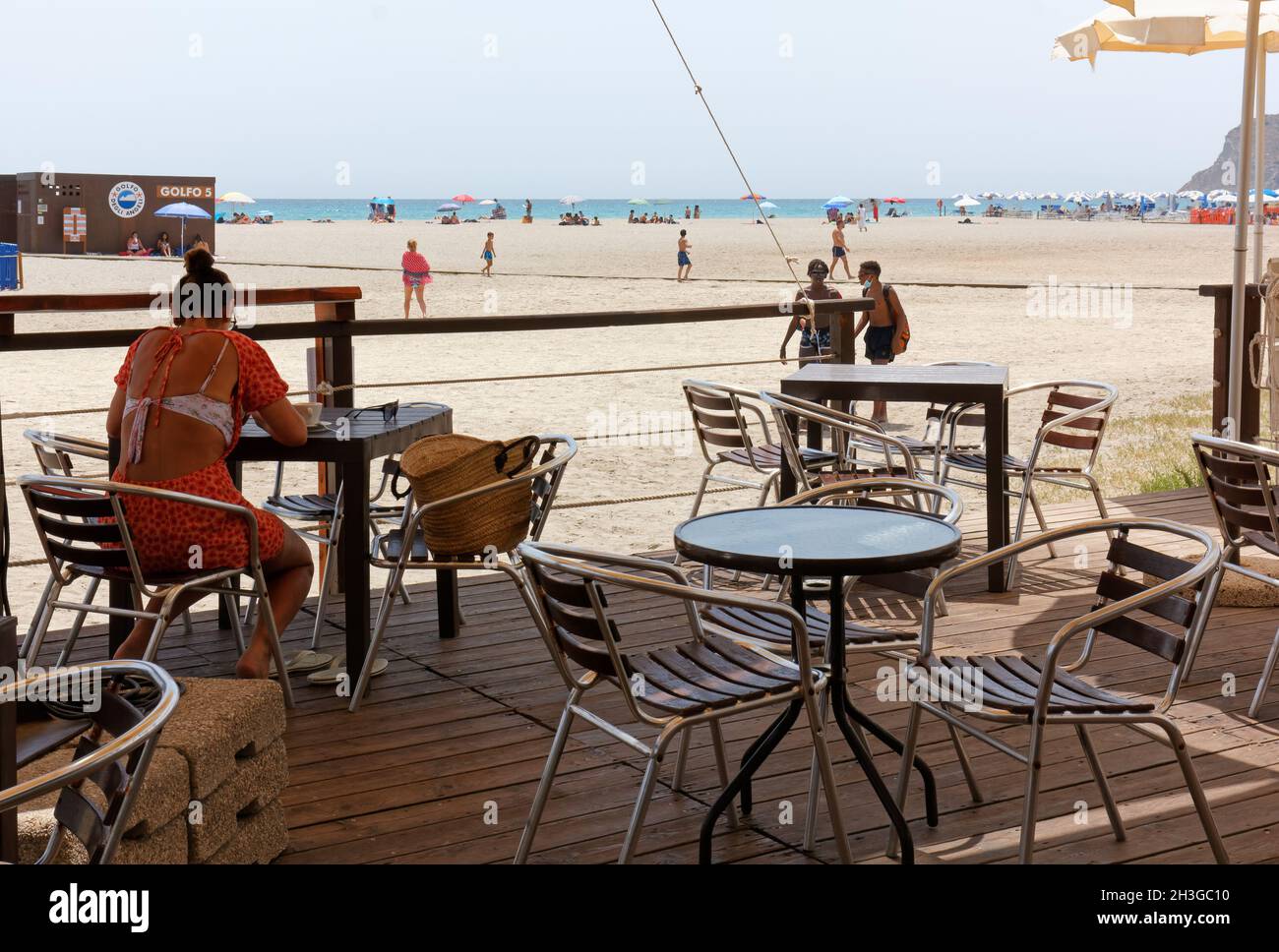 CAGLIARI, Italia - 07 de julio de 2021: La vida en la playa de Poetto cerca de  la ciudad, con una joven sentada en la mesa de un comedor Fotografía de  stock - Alamy
