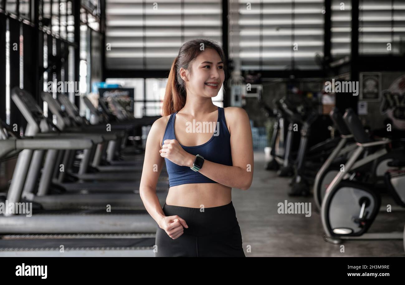deportista en forma asiática sonriendo y haciendo ejercicio con pesas con  pesas en el gimnasio. mujer