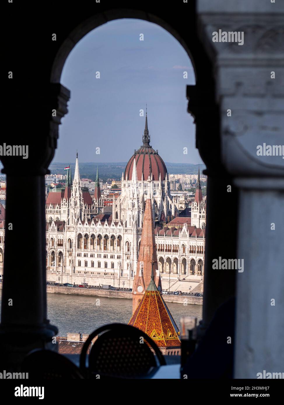 Parlamento de Budapest en el sol de la tarde: El Danubio y el Parlamento húngaro en Pest de la colina del castillo en Buda, enmarcado por los arcos de la Warf Fishermans. Foto de stock