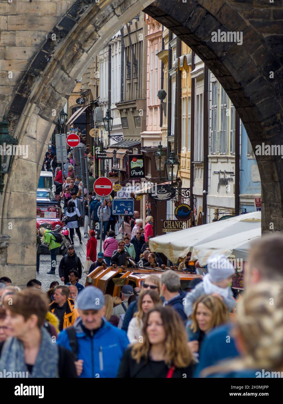 Calle comercial ocupada de Praga: La vista a través de la Torre de la Pólvora en Praga Muchos compradores y turistas se agolpan en la popular calle comercial. Foto de stock