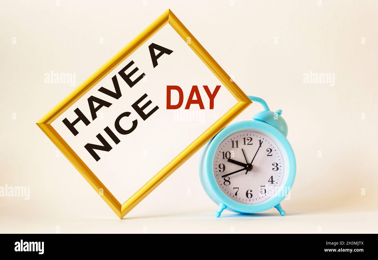 Tenga un signo de buen día, en un marco de fotos con fondo blanco, junto a  un reloj despertador Fotografía de stock - Alamy