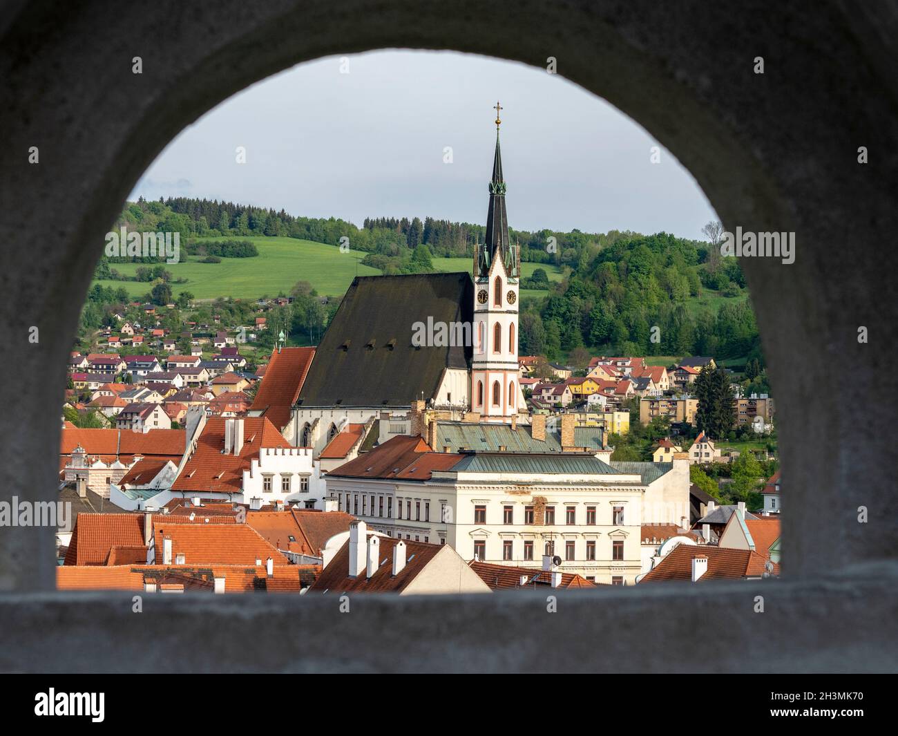 Vista de Cesky Kromlov desde el Castillo Walk: Imagen de la ciudad de Cesky Krumlov y la Iglesia de San Vito enmarcada por uno de los arcos de la pasarela del castillo. Foto de stock
