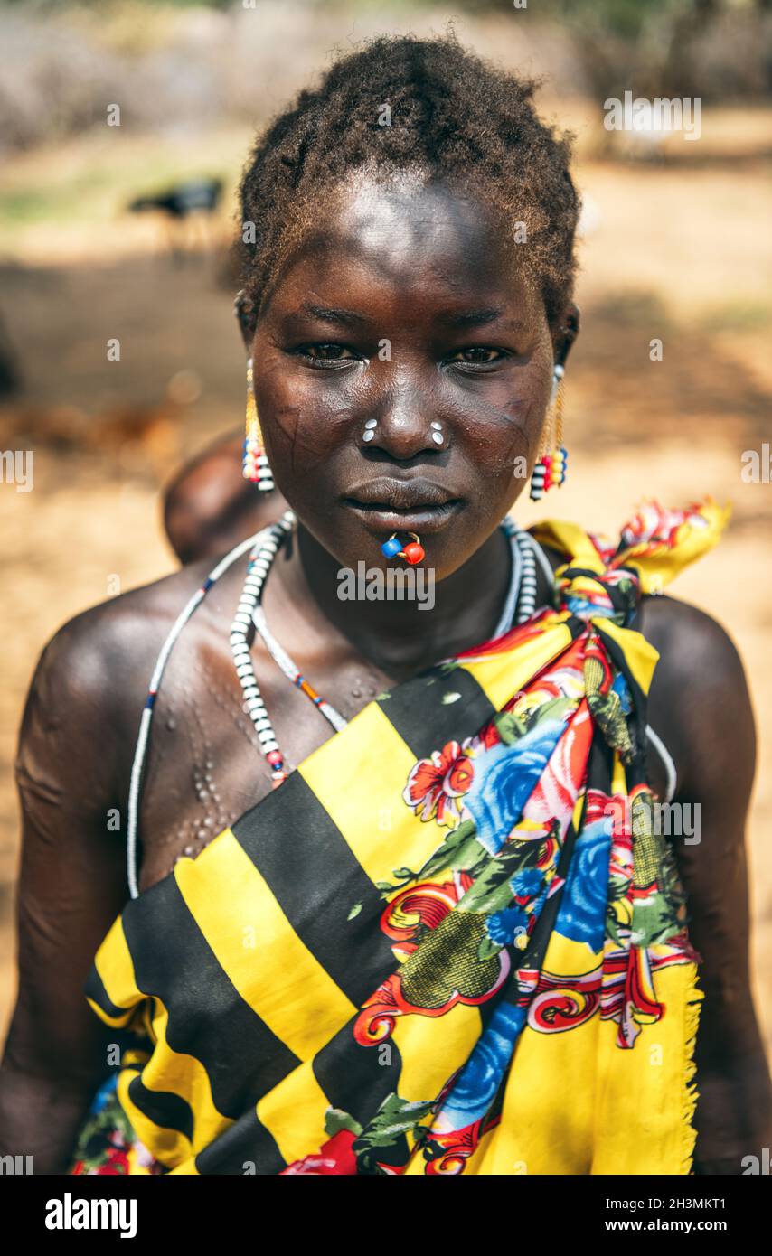 TRIBU BOYA, SUDÁN DEL SUR - 10 DE MARZO de 2020: Mujer con ropa tradicional de colores y accesorios con perforación ritual y cicatriz mo Foto de stock