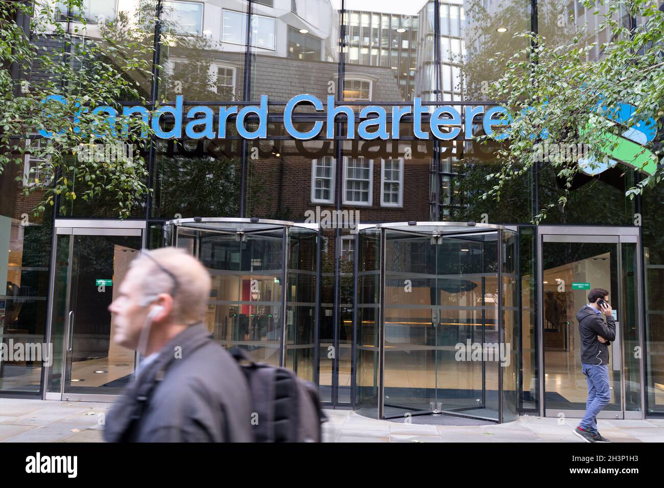 Entrada principal con enorme banner para el banco de inversión Standard Chartered Bank, sede central, ciudad de Londres Inglaterra Reino Unido Foto de stock