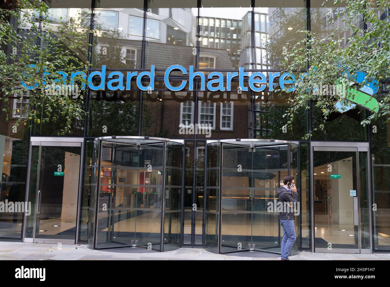 Entrada principal con enorme banner para el banco de inversión Standard Chartered Bank, sede central, ciudad de Londres Inglaterra Reino Unido Foto de stock