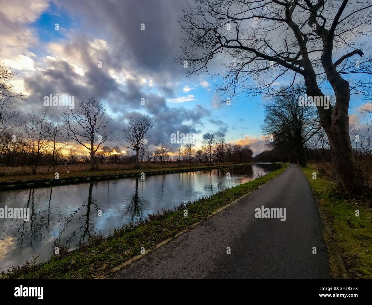 Vista panorámica de una hermosa puesta de sol sobre el río en primavera contra el fondo del cielo azul y dorado, el sol sobre la w Foto de stock