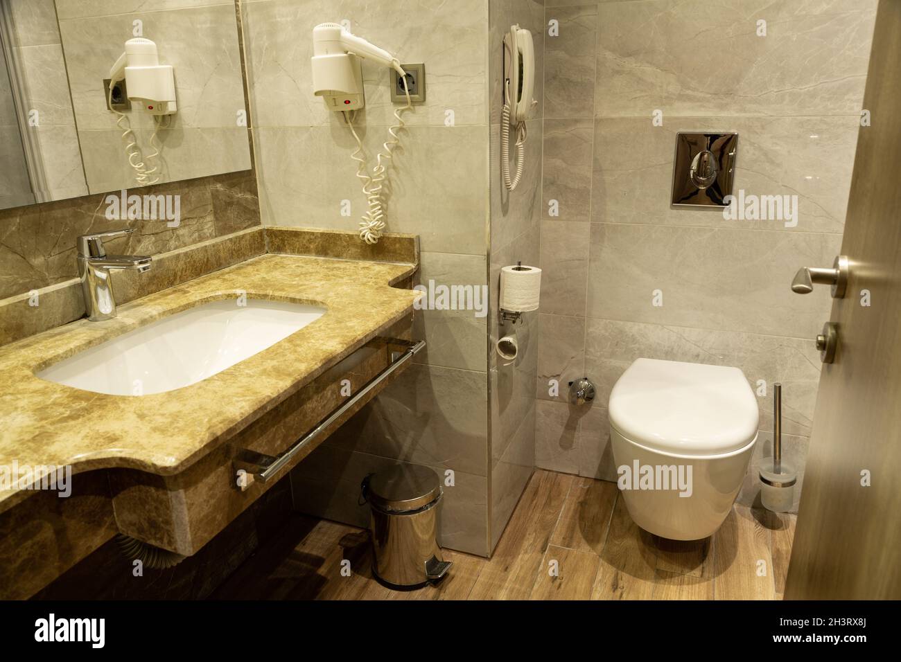 Baño moderno. Está amueblado con azulejos estampados de piedra natural. Foto de stock
