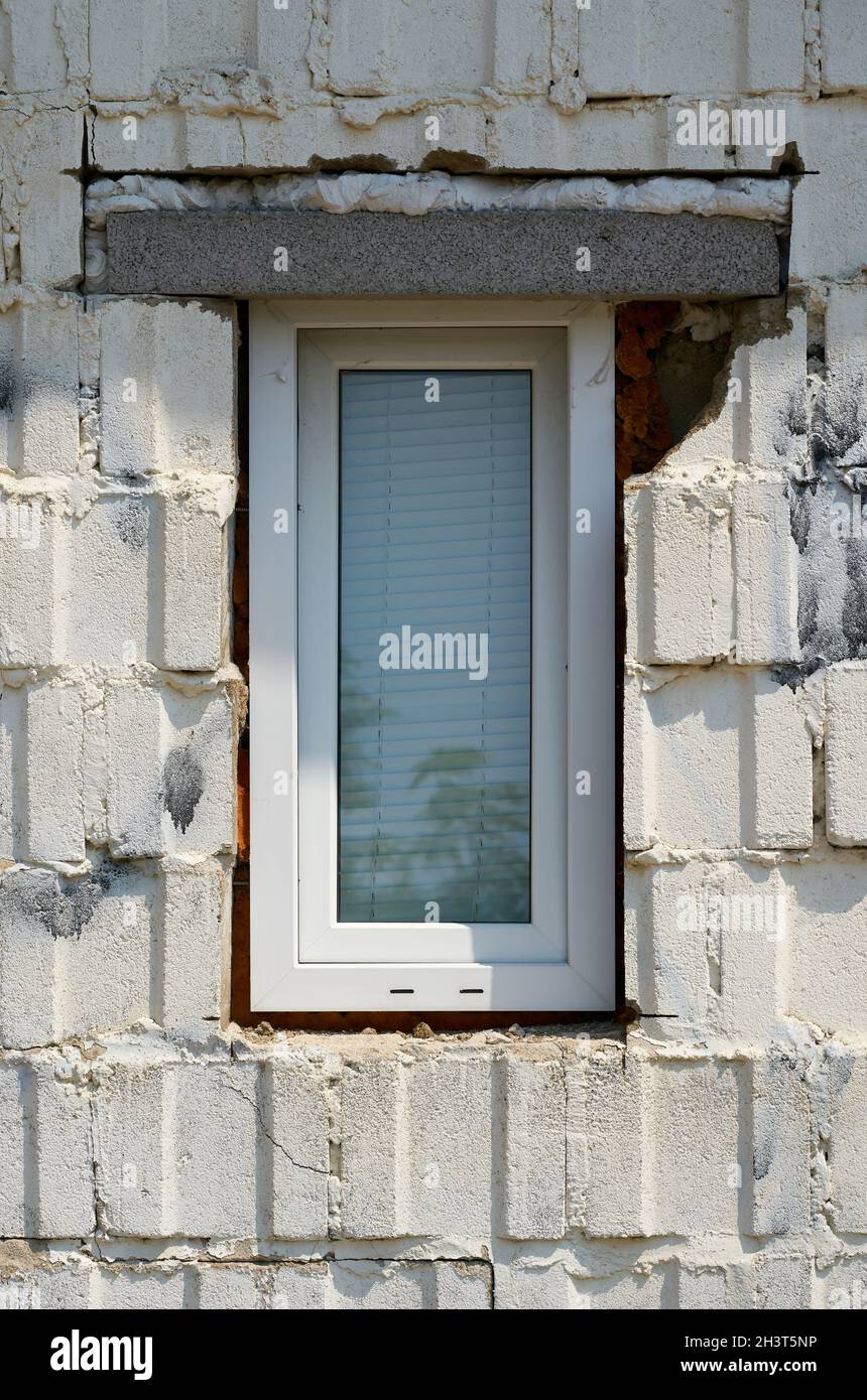Ventana instalada de forma no profesional en la fachada de una casa con defectos de construcción Foto de stock