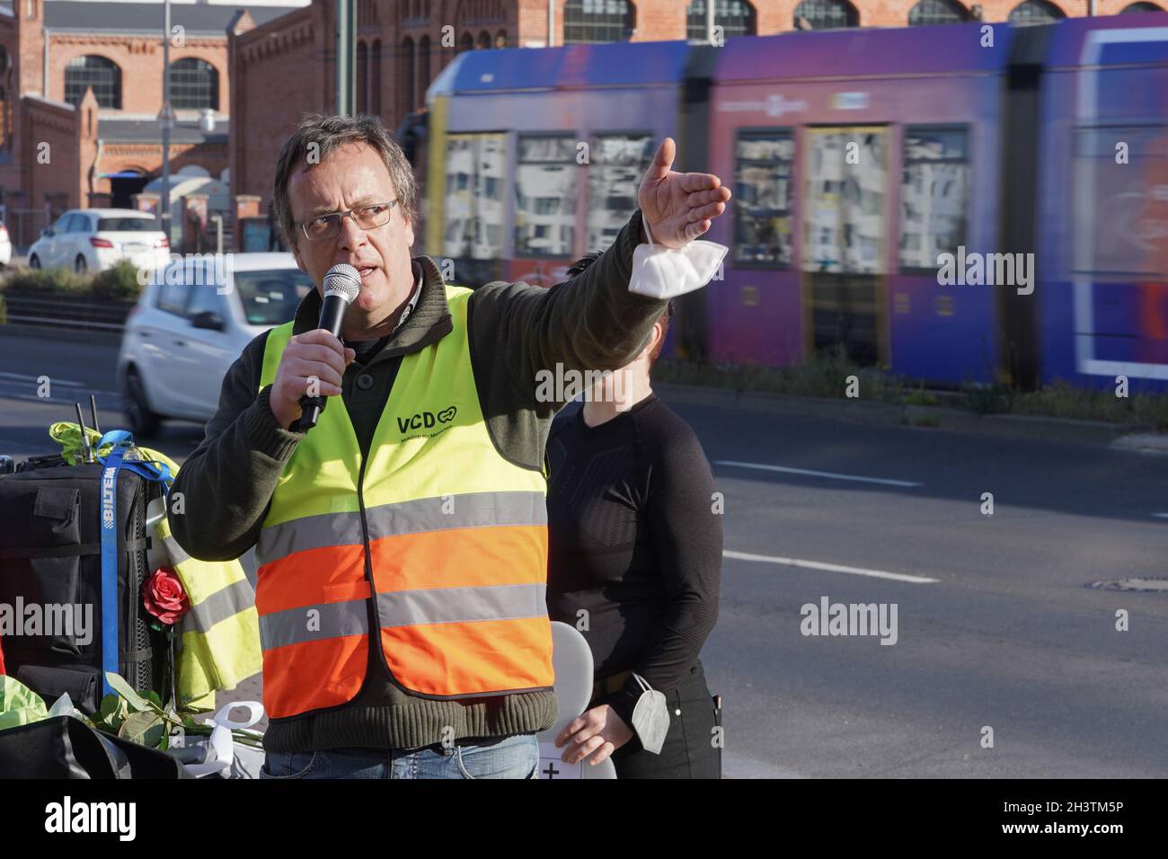 Berlín, Alemania. 30th Oct, 2021. Heiner von Marschall, presidente regional del Verkehrsclub Deutschland (VCD), habla con los presentes en una vigilia de peatones muertos en Landsberger Allee, a nivel de Fritz-Riedel-Straße y Hausburgstraße. Conmemoran a un hombre de 56 años que fue golpeado y herido fatalmente por un tranvía el 14 de septiembre de 2021. Crédito: Jörg Carstensen/dpa/Alamy Live News Foto de stock