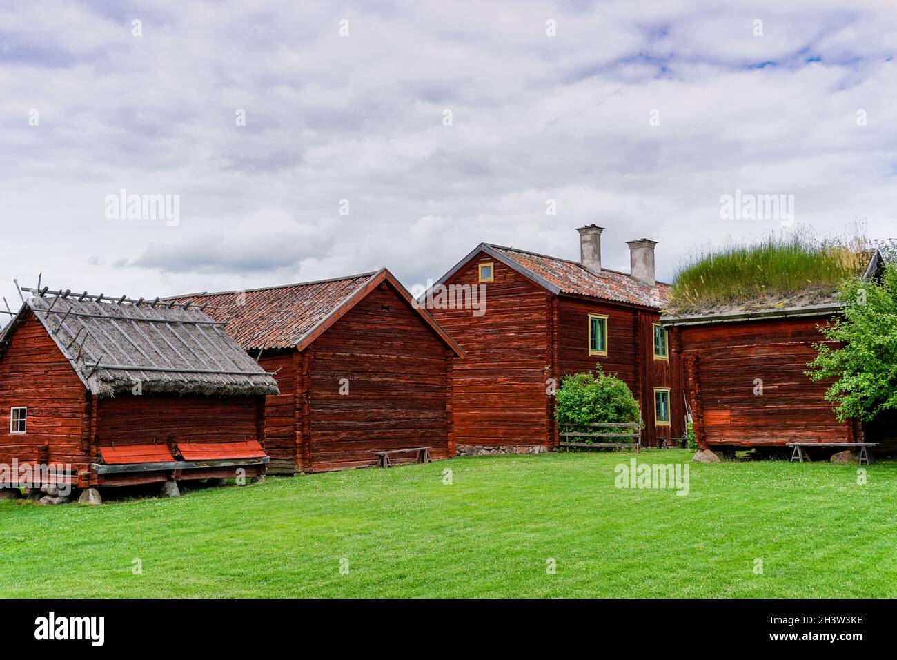 Casas de campo idílicas de color rojo en el país sueco con prados verdes en un hermoso día de verano Foto de stock