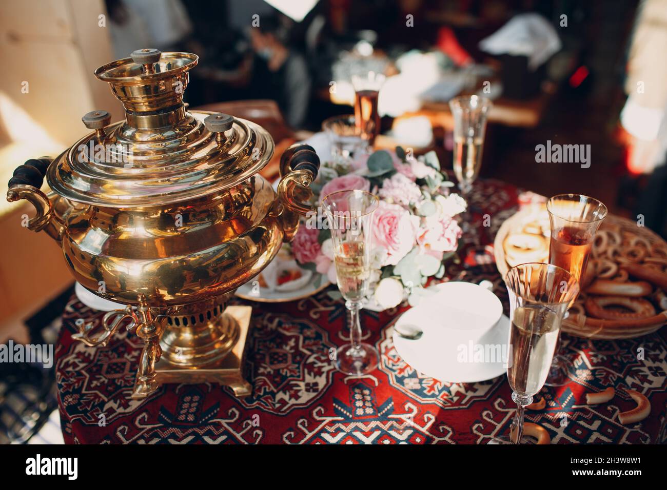 Mesa rusa tradicional para tomar té con un samovar, vasos de vino, flores,  pasteles, bagels y bollos Fotografía de stock - Alamy