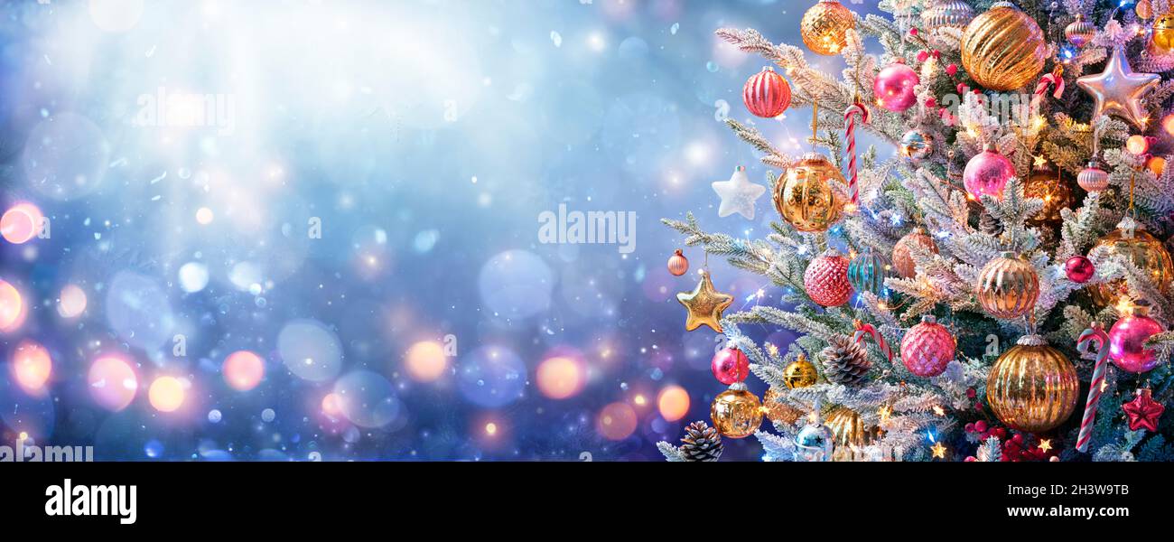 Árbol de Navidad - Ornamentos y Nieve en Fondo Azul con Luces Brillantes Foto de stock