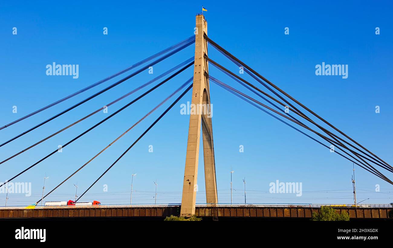 Ucrania, Kiev - 20 de agosto de 2019: Un puente a través del río con cuerdas de tracción. Puente Norte con el telón de fondo de una hermosa Foto de stock
