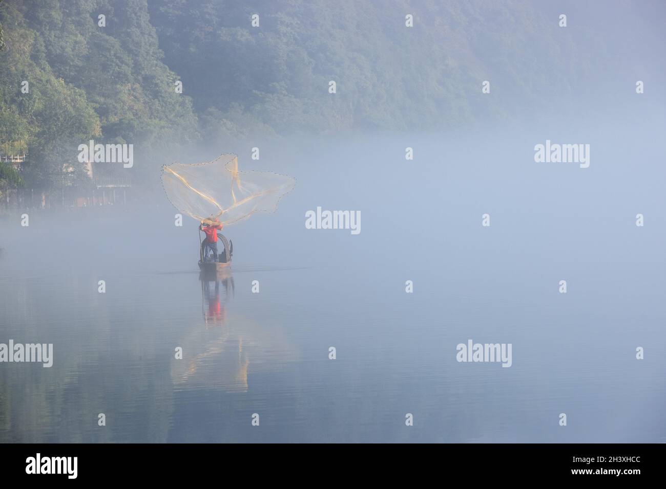 Red de pesca de fundición cierre en el río de niebla Foto de stock