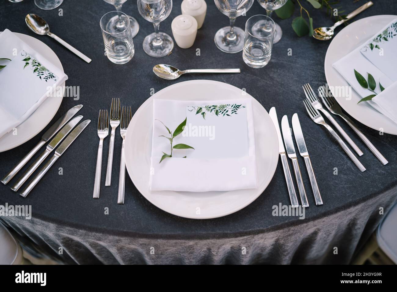 Recepción de mesa para bodas. Platos redondos blancos sobre una mesa  redonda con manteles grises, sillas Chiavari blancas con pilla blanca  Fotografía de stock - Alamy