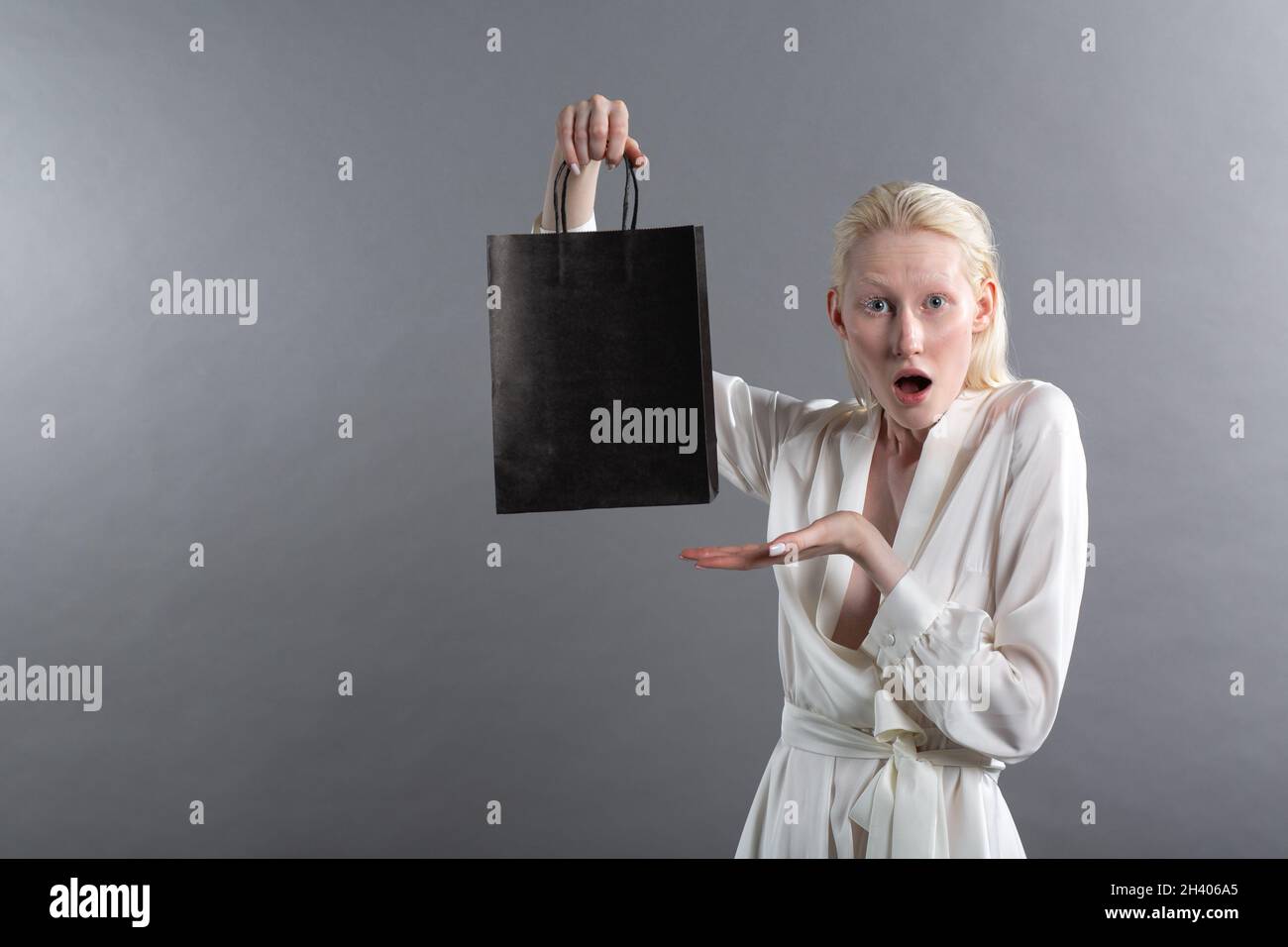 Blanca mujer albino rubia caucásica sostiene la bolsa de la compra. Venta y  descuentos en el mercado y el concepto Black Friday Fotografía de stock -  Alamy