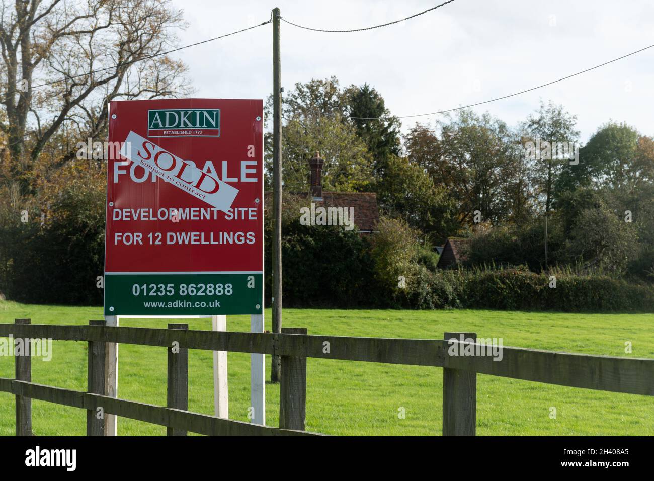 Sitio Greenfield con un cartel vendido, Sitio de desarrollo para 12 viviendas en el pueblo de Bramley, Hampshire, Inglaterra, Reino Unido Foto de stock