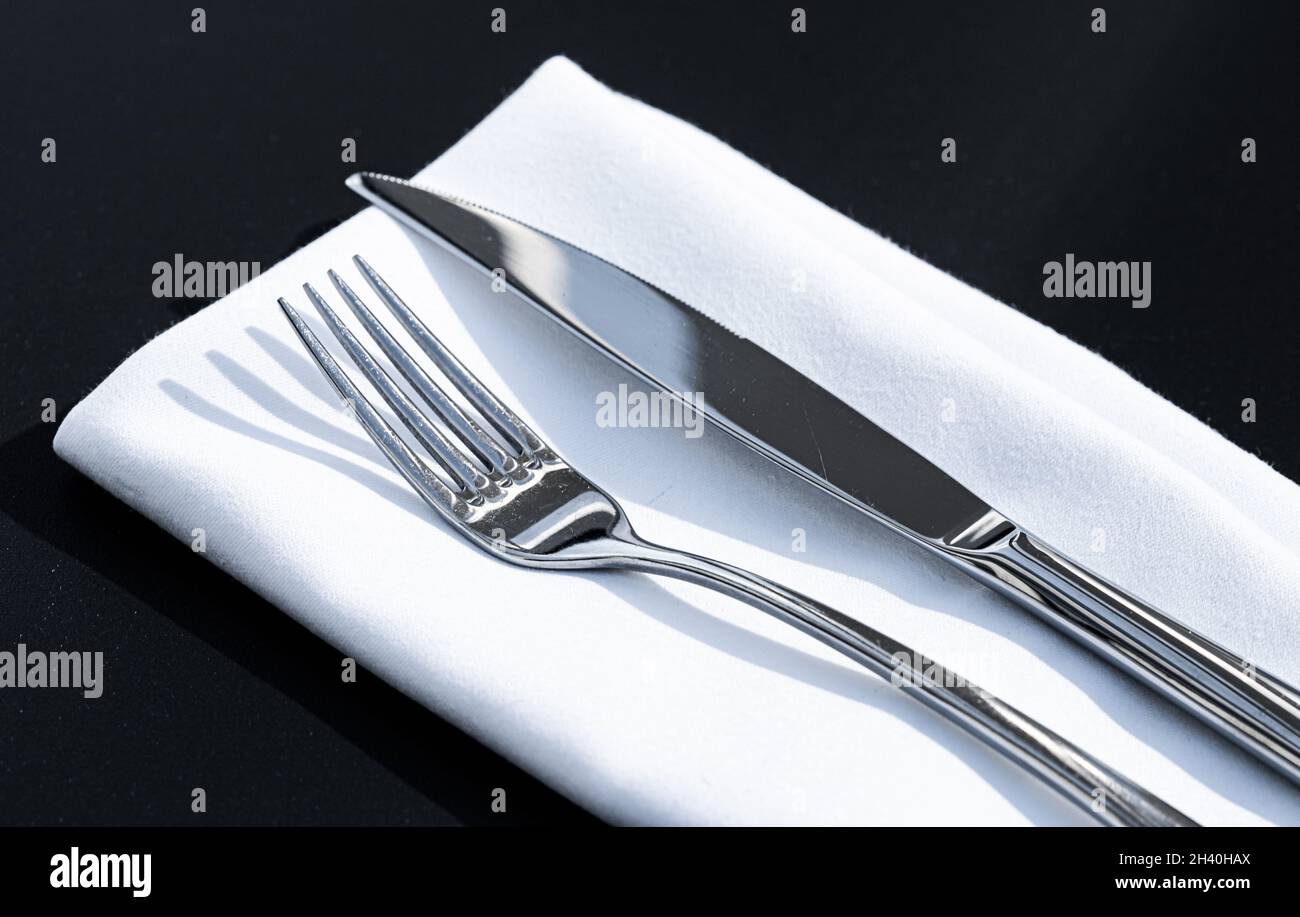 Tenedor y cuchillo con servilleta blanca en la mesa en un restaurante de  lujo al aire libre, menú fino de la cena para la boda o el acontecimiento y  el abastecimiento de