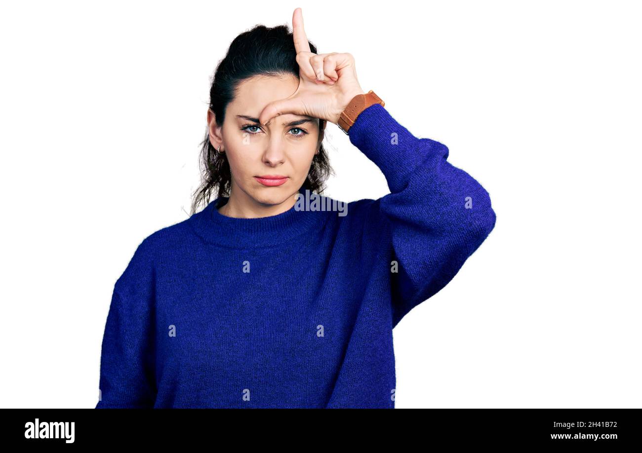 Joven mujer hispana usando ropa casual haciendo diversión de personas con  los dedos en la frente haciendo un gesto perdedor burlándose e insultando  Fotografía de stock - Alamy